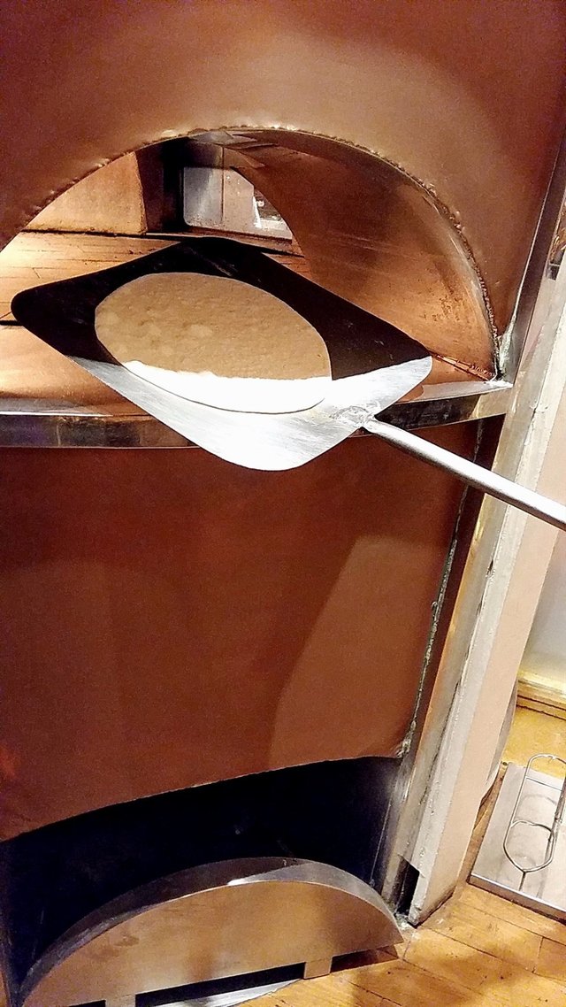 put the dough into the wood-fired oven